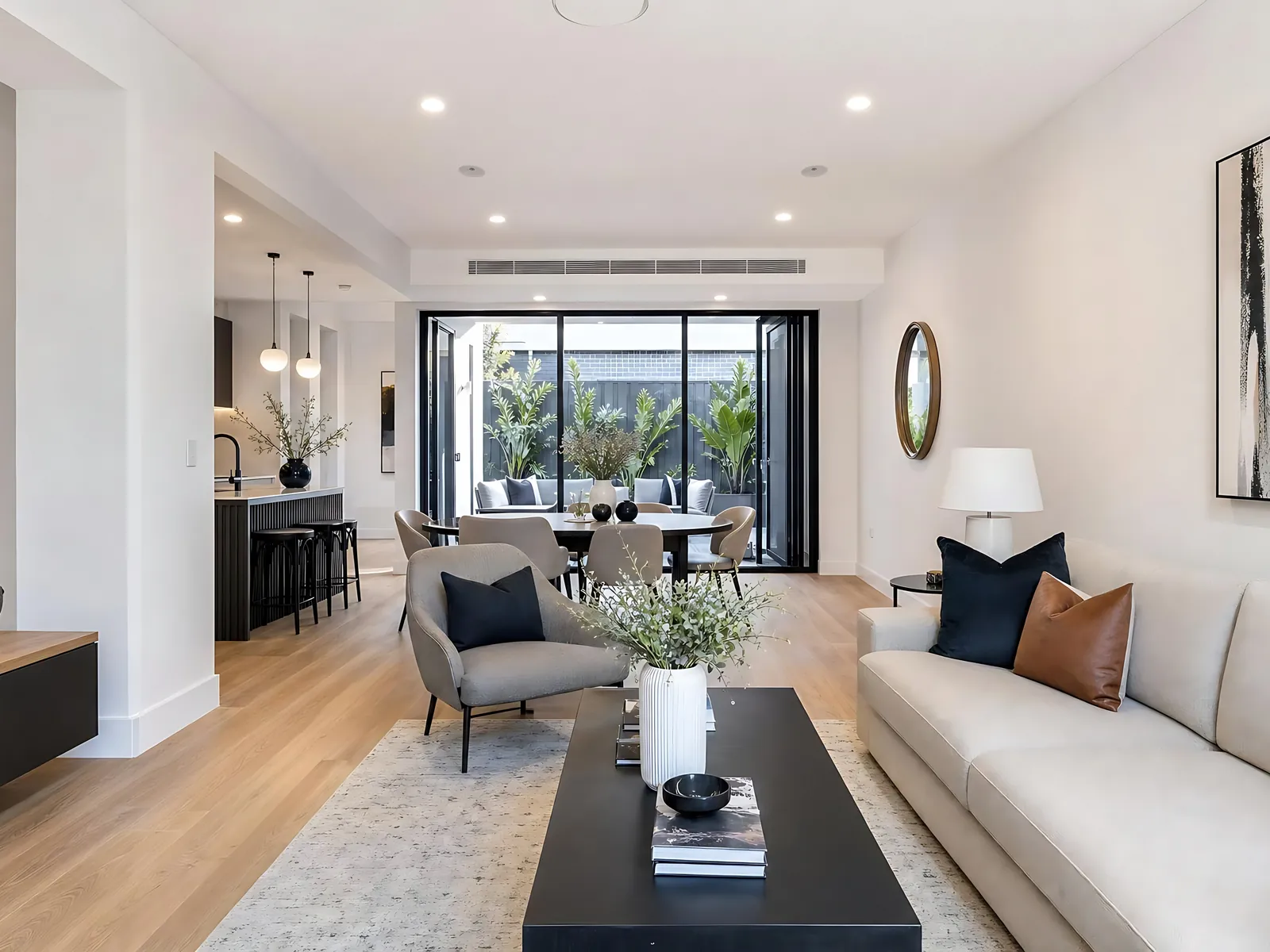 Long open-plan living and dining room with a sofa, kitchen and garden doors